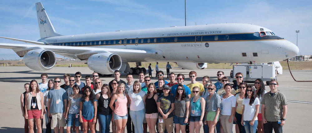students in front of airplane